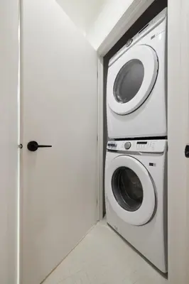 a washer and dryer in a room with a door at New and Cozy 3 bedroom in Le Plateau by Denstays in Montréal