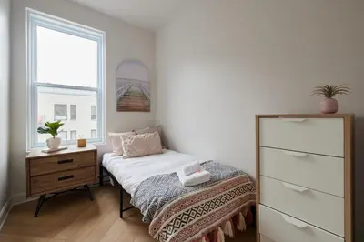 a bedroom with a bed and a dresser and a window at New and Cozy 3 bedroom in Le Plateau by Denstays in Montréal