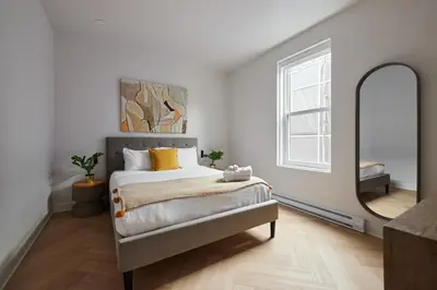 a bedroom with a bed and a large mirror at New and Cozy 3 bedroom in Le Plateau by Denstays in Montréal