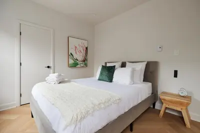 a bedroom with a large white bed and a table at Spacious 2 bedroom apartment in Le Plateau by Denstays in Montréal