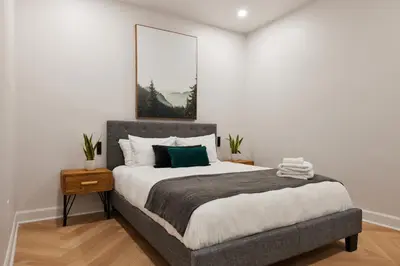 a bedroom with a bed with a picture on the wall at Spacious 2 bedroom apartment in Le Plateau by Denstays in Montréal