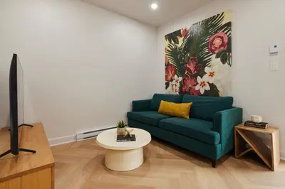 a living room with a blue couch and a tv at Spacious 2 bedroom apartment in Le Plateau by Denstays in Montréal