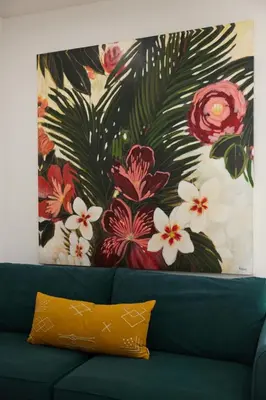 a painting of flowers on the wall above a couch at Spacious 2 bedroom apartment in Le Plateau by Denstays in Montréal