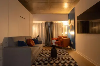 a living room with a couch and a chair at Downtown Montreal Premium Cozy Studio in Montréal