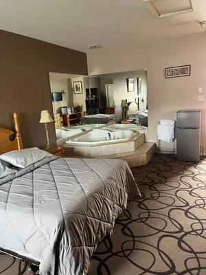 a bedroom with a large bed and a bath tub at Motel la siesta de gascon in Terrebonne
