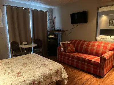 a living room with a couch and a bed at Motel la siesta de gascon in Terrebonne