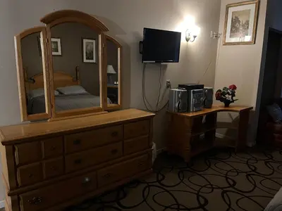 a bedroom with a dresser and a large mirror at Motel la siesta de gascon in Terrebonne