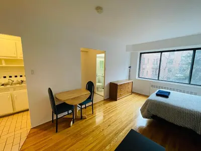 a room with a table and a bed and a table and chairs at Stylish Montreal Apartment: Comfortable Stay in the Golden Square Mile in Montréal