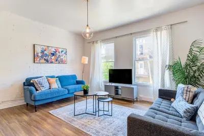 a living room with a blue couch and a tv at Chez Mont Royal Apartments! in Montréal