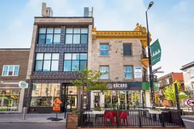 a brick building with red tables in front of it at Chez Mont Royal Apartments! in Montréal