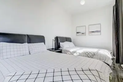 two beds in a room with white walls at Chez Mont Royal Apartments! in Montréal