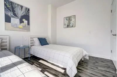 two beds in a room with white walls at Chez Mont Royal Apartments! in Montréal