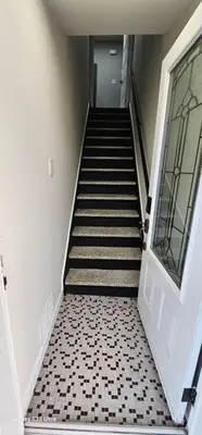 a hallway with a staircase leading to a door at Spacious bright Apt,Parking and self check-in in Longueuil