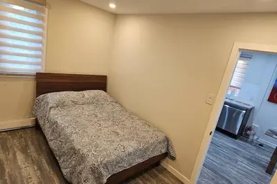 a bedroom with a bed in the corner of a room at Spacious bright Apt,Parking and self check-in in Longueuil