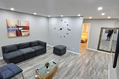 a living room with a couch and a clock on the wall at Spacious bright Apt,Parking and self check-in in Longueuil