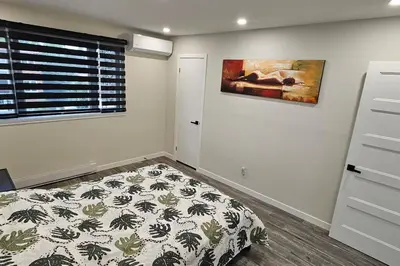a bedroom with a bed and a painting on the wall at Spacious bright Apt,Parking and self check-in in Longueuil