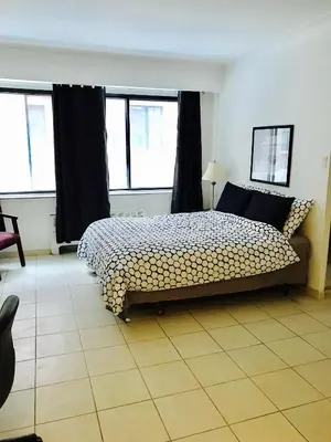 a bedroom with a bed and two windows at Stylish Montreal Apartment: Comfortable Stay in the Golden Square Mile in Montréal