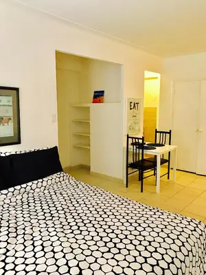 a bedroom with a bed and a table and a chair at Stylish Montreal Apartment: Comfortable Stay in the Golden Square Mile in Montréal