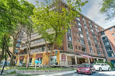 a red car parked in front of a building at Stylish Montreal Apartment: Comfortable Stay in the Golden Square Mile in Montréal