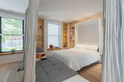 a bedroom with a bed and a large window at Chez moi - Plateau - Superbe Stay - Excellent emplacement - très confortable in Montréal