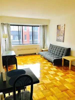a living room with a couch and a table at Stylish Montreal Apartment: Comfortable Stay in the Golden Square Mile in Montréal