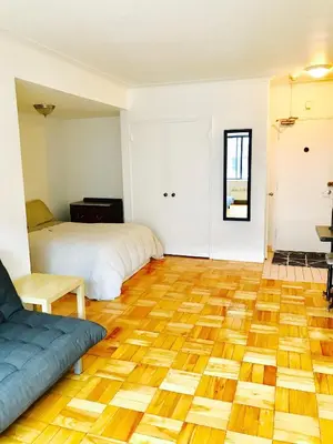 a room with two beds and a wooden floor at Stylish Montreal Apartment: Comfortable Stay in the Golden Square Mile in Montréal