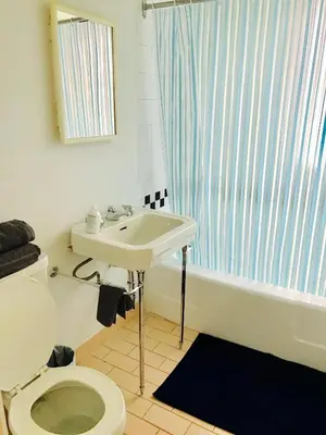 a bathroom with a toilet and a sink and a tub at Stylish Montreal Apartment: Comfortable Stay in the Golden Square Mile in Montréal