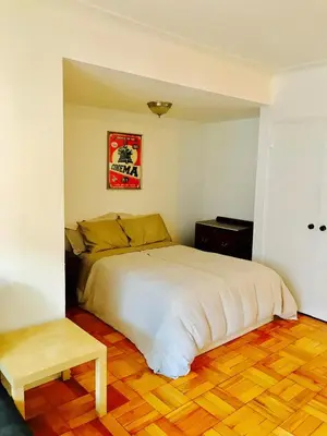 a bedroom with a white bed and a wooden floor at Stylish Montreal Apartment: Comfortable Stay in the Golden Square Mile in Montréal