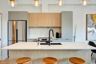 a kitchen with a sink and a counter with stools at Penthouse Downtown 2BR 2 BR Private Roof Terrace presented by TripMontreal in Montréal