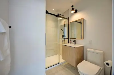 a bathroom with a shower and a toilet and a sink at Penthouse Downtown 2BR 2 BR Private Roof Terrace presented by TripMontreal in Montréal