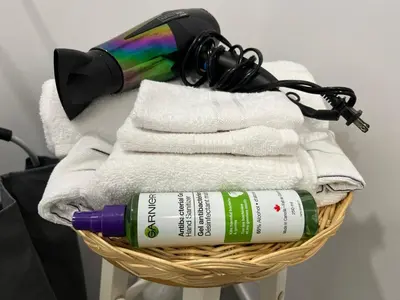 a basket filled with towels and a bottle of wine at Bertha's charming urban retreat in Laval