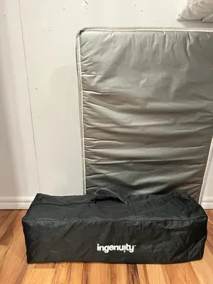 a black sleeping bag sitting on a wooden floor at Bertha's charming urban retreat in Laval