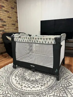 a baby crib sitting on a rug in a room at Bertha's charming urban retreat in Laval