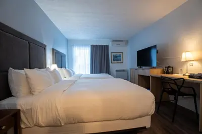 a hotel room with a large bed and a desk at Hotel Lac Brome, BW Signature Collection in Lac-Brome