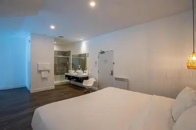a bedroom with a white bed and a bathroom at Hotel Lac Brome, BW Signature Collection in Lac-Brome