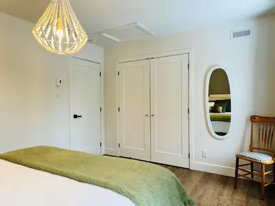 a bedroom with a bed and a chandelier at Woodpecker Spa and peace in Orford