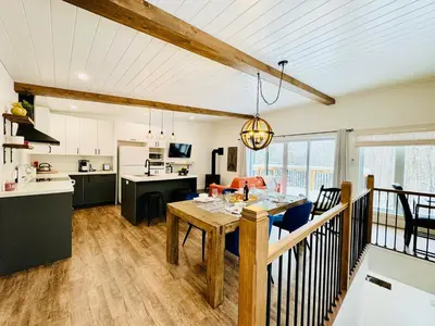 a kitchen and living room with a table in a room at Woodpecker Spa and peace in Orford