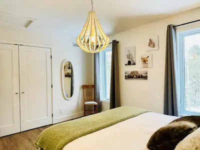 a bedroom with a bed and a chandelier at Woodpecker Spa and peace in Orford