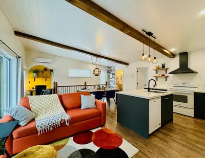 a living room with a red couch and a kitchen at Woodpecker Spa and peace in Orford