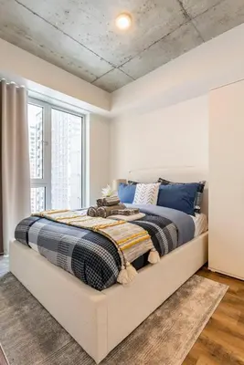 a bedroom with a large bed with blue pillows at Executive Class Apartments with Gym for VIP & Students in Downtown MTL in Montréal