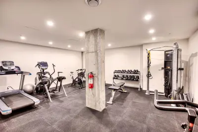 a gym with several exercise equipment in a room at Executive Class Apartments with Gym for VIP & Students in Downtown MTL in Montréal
