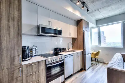 a kitchen with a stove and a microwave at Executive Class Apartments with Gym for VIP & Students in Downtown MTL in Montréal