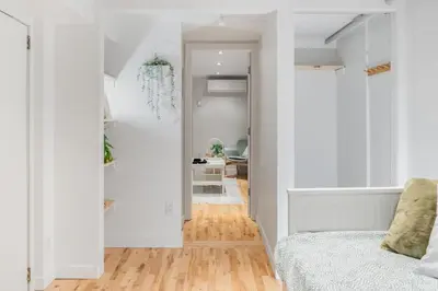a bedroom with white walls and a bed and a hallway at Magnificent 2BR Apartment fully equipped in Montréal