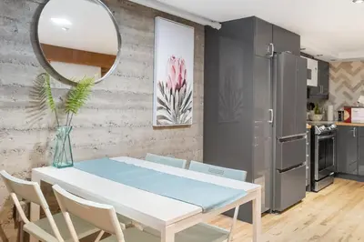 a dining room with a white table and a mirror at Magnificent 2BR Apartment fully equipped in Montréal