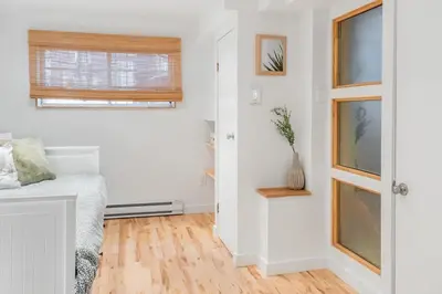 a white room with a bed and a window at Magnificent 2BR Apartment fully equipped in Montréal