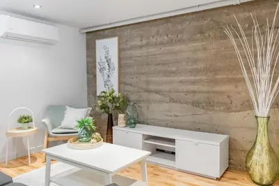 a living room with a white table and a wooden wall at Magnificent 2BR Apartment fully equipped in Montréal
