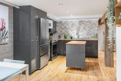 a kitchen with stainless steel appliances and wooden floors at Magnificent 2BR Apartment fully equipped in Montréal