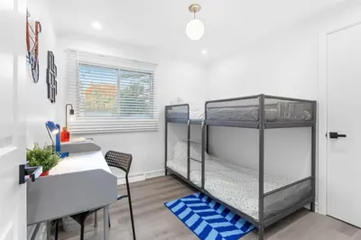 a bedroom with two bunk beds and a desk at Spacious Urban Cabin in West Montreal - 4BR in Montréal
