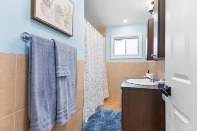 a bathroom with a sink and a toilet and a mirror at Spacious Urban Cabin in West Montreal - 4BR in Montréal