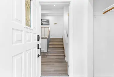 a hallway with a white door and stairs at Spacious Urban Cabin in West Montreal - 4BR in Montréal